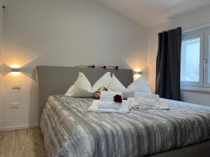 Un dormitorio con una cama grande con toallas. en Villa Renè, en Tenno