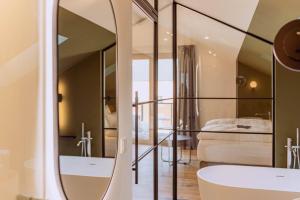 a bathroom with a mirror and a bed in a room at KABINETT Boutique Apartments in Kröv +133 photos