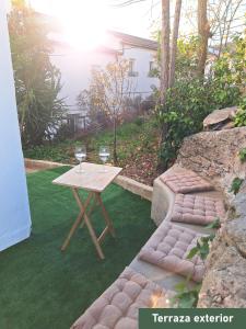 a table and two glasses of wine on a lawn at Casa rural El Rincón de la Yedra in Setenil