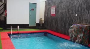 a large swimming pool in a room with a red and green floor at 3pila homes in Ogba