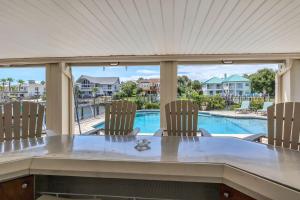 mesa de comedor con sillas y vistas a la piscina en Waterfront Dream House Pool Golf Cart & Dock, en Destin