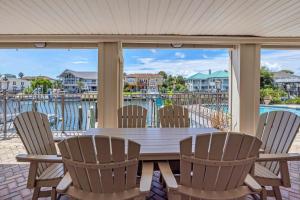 una mesa y sillas en un porche con vistas al agua en Waterfront Dream House Pool Golf Cart & Dock, en Destin