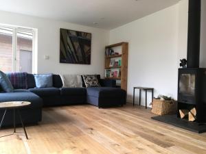 a living room with a blue couch and a tv at St Vincents in Kingussie