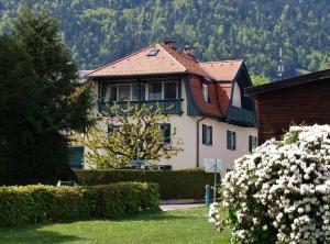 une maison blanche avec un toit rouge dans l'établissement Ferienwohnungen Steger, à Bodensdorf