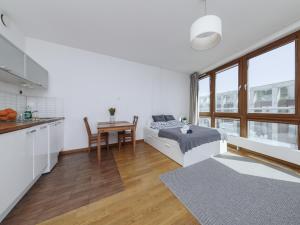 a bedroom with a bed and a table in a kitchen at Luxury apartment Piękna in Warsaw