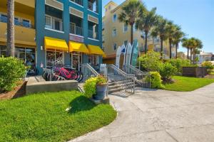 Un edificio con palmeras y tablas de surf delante. en Gulf Place - Beach Burrow, en Santa Rosa Beach