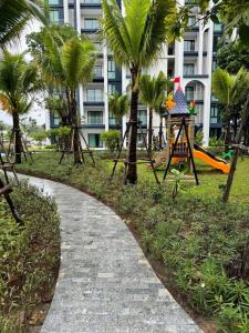 a path in a park with palm trees and a building at Super Naiyang Title 1Bdr 600m to beach in Nai Yang Beach