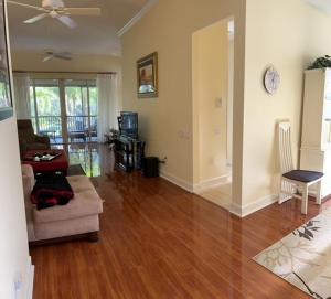 a living room with a couch and a clock on the wall at Botanica Condo in Sarasota +6 photos