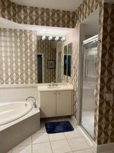 a bathroom with a tub and a sink and a shower at Botanica Condo in Sarasota