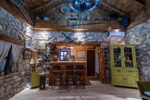 a room with a stone wall and a bar with stools at Peuta Hill in Podgorica