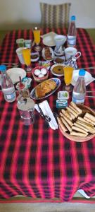 a table with food on a red and black table cloth at Chambre dans une maison d'hôtes in Medenine