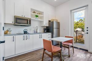 a kitchen with white cabinets and a table and chairs at Vibrant Austin Studio Balcony plus Parking and Wi-Fi in Austin