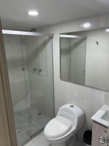a bathroom with a toilet and a glass shower at Hotel Urbano 70 in Medellín +37 photos