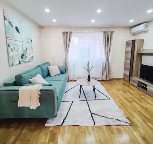 a living room with a green couch and a table at Volo House in Cluj-Napoca