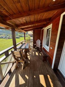 a wooden deck with a table and benches on it at Живописні карпати in Slavske