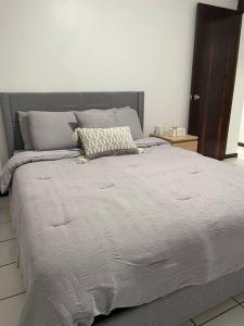 a large bed with a gray comforter in a bedroom at Lovely 2 bedroom condo 2min walking to the beach in Monserrate