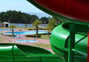 a green slide in a park with a pool at Guesthouse Santos & Belos in Nazaré