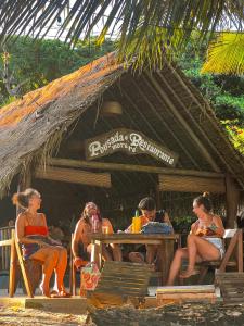 a group of people sitting at a table on the beach at Pousada Moreré in Ilha de Boipeba +65 photos