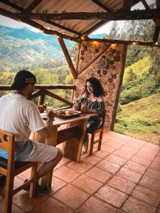 a man and a woman sitting at a table on a patio at Glamping La Kumbre Gama C in Gama +6 photos