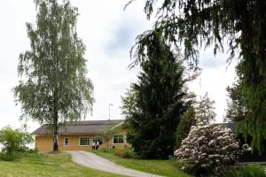a house with a tree in front of it at Keltainen talo - tilava huvila lähellä Saloa in Vartsala