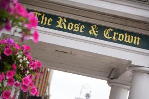 a sign that reads the house of cylon on a building with flowers at The Rose & Crown Hotel in Tonbridge