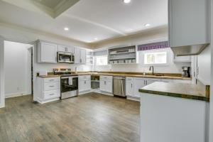 a kitchen with white cabinets and a wooden floor at Walk to Winery Family-Friendly Holt Getaway in Kearney
