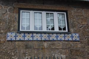 a window on a stone building with blue and white tiles at Casa da Quinta De S. Martinho in Vila Real