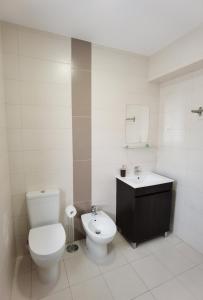 a white bathroom with a toilet and a sink at Sky and Sand Hostel in Portimão +17 photos