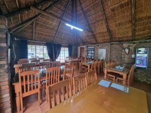 a dining room with tables and chairs in a building at Emerald Guesthouse in Kempton Park
