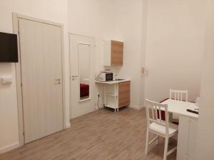 a small white room with a desk and a microwave at Residence e appartamenti Bausan in Naples