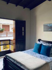 ein Schlafzimmer mit einem Bett mit blauen Kissen und einem Balkon in der Unterkunft Hotel Plenitud Jardín in Jardin + 29 Fotos