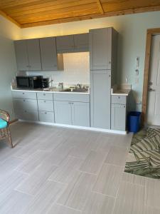 a kitchen with white cabinets and a wooden ceiling at Deer Run on the Atlantic in Big Pine Key