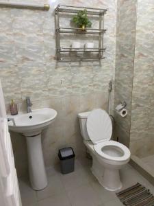 ein Badezimmer mit einer weißen Toilette und einem Waschbecken in der Unterkunft Appartement meublé 3 chambres Cité Mixta in Grand Médina