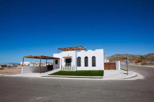 a small white house on the side of a road at Exclusive pool house in Bahía Kino