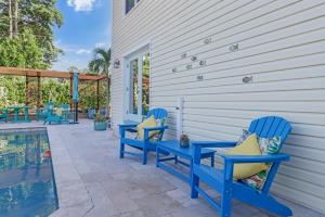 two blue chairs on a patio next to a pool at Coastal Soul House in the heart of Naples in Naples