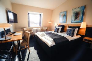una camera d'albergo con un letto grande e una scrivania di Struer Grand Hotel a Struer
