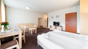 a hotel room with a bed and a dining room at Karpacz Residence 107A in Karpacz