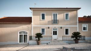 a house with two palm trees in front of it at Quinta da Carlota in Torres Vedras