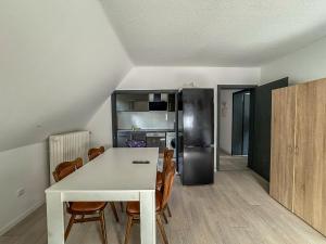 a kitchen with a white table and chairs and a refrigerator at Cici Monteurunterkünfte in Werdohl mit Küche, WLAN, TV, Parken in Werdohl +3 photos