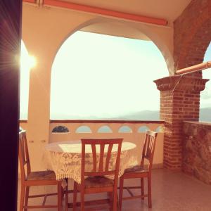 Una mesa y sillas en un balcón con vista. en B&B Castello Michelina, en San Nicola dellʼAlto