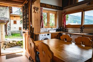 kuchnia z drewnianym stołem, krzesłami i kuchenką w obiekcie Chalet La Plagne jacuzzi vue top w mieście Montchavin