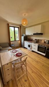 a kitchen with a table and chairs in a room at T2 cocon avec balcon et parking in La Roche-sur-Foron