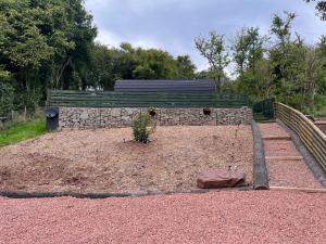 GloucestershireMushroom Pod的墙上有一张长椅的花园