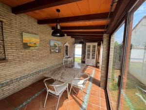 patio z 2 krzesłami i ceglaną ścianą w obiekcie VILLA ANDEMAR w mieście Chiclana de la Frontera