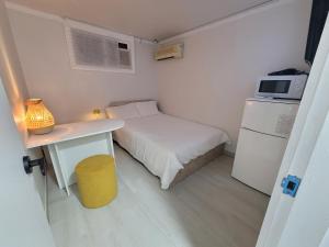 a small room with a bed and a table and a microwave at stay110 in Seoul +42 photos