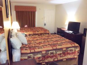 a hotel room with two beds and a television at Plum Tree Inn in Williamstown