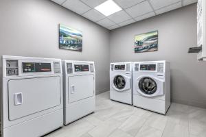 a laundry room with three washing machines in it at Holiday Inn Express Hotel & Suites Marshall by IHG in Marshall