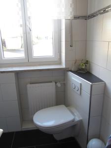 a white bathroom with a toilet and a window at Ferien auf dem Bauernhof in Moosbach