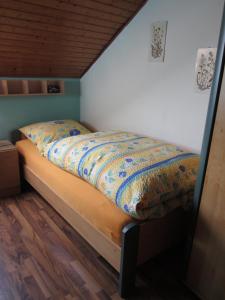 a bed with a colorful comforter in a bedroom at Ferien auf dem Bauernhof in Moosbach