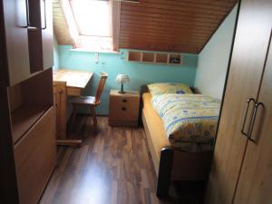 a small bedroom with a bed and a desk at Ferien auf dem Bauernhof in Moosbach